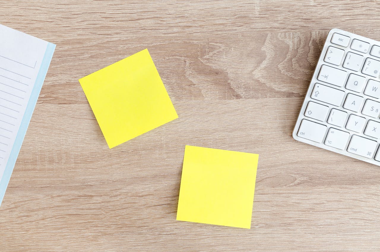 Mastering the First Impression: Your intriguing post title goes here Flat lay of a workspace featuring yellow sticky notes, a keyboard, and a notebook on a wooden desk.